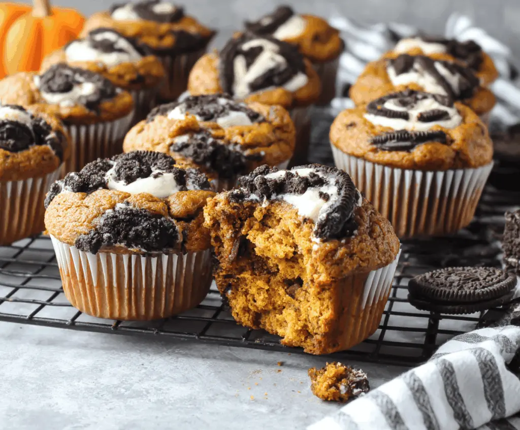 Delicious homemade pumpkin Oreo muffins with a moist pumpkin base and crushed Oreo cookie topping on a baking tray.