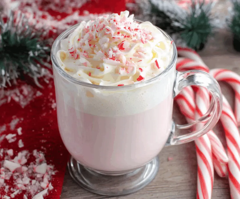 Creamy Crockpot Candy Cane White Hot Chocolate garnished with whipped cream and crushed peppermint for a festive treat.
