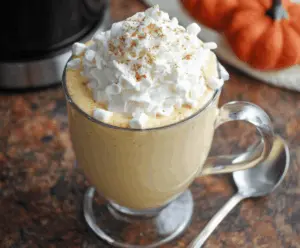 Creamy Crockpot Pumpkin Pie White Hot Chocolate in a cozy mug with whipped cream and cinnamon topping.