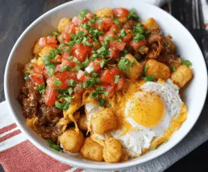 Delicious Tater Tot Breakfast Bowl with eggs, cheese, and fresh vegetables for a hearty morning meal