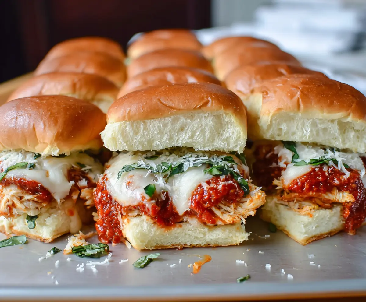 Delicious Garlic Chicken Parmesan Sliders topped with melted cheese and fresh herbs.
