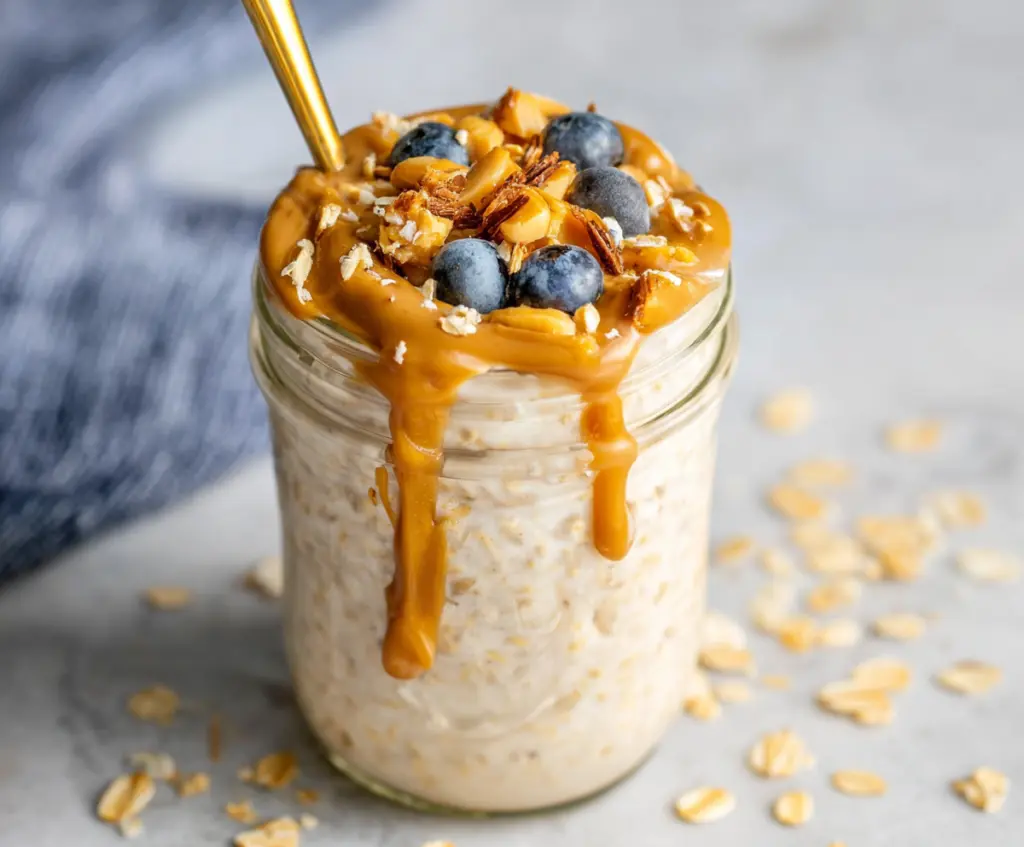Creamy peanut butter overnight oats in a glass jar with sliced bananas and honey topping