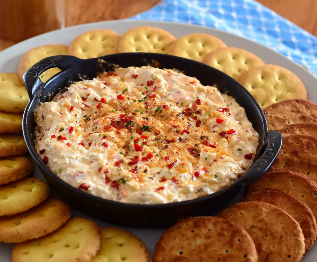 Spicy Alabama Fire Cracker Dip served in a bowl, garnished with herbs, perfect for parties.