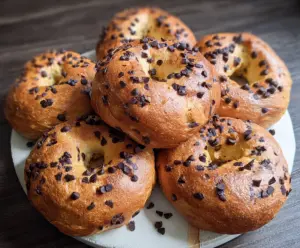 Bowl of freshly baked chocolate chip bagels on a cooling rack