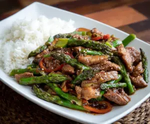 Delicious pork and fresh asparagus stir fry served in a bowl for a healthy meal option.
