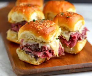 Delicious corned beef sliders with melted cheese and fresh toppings on a plate