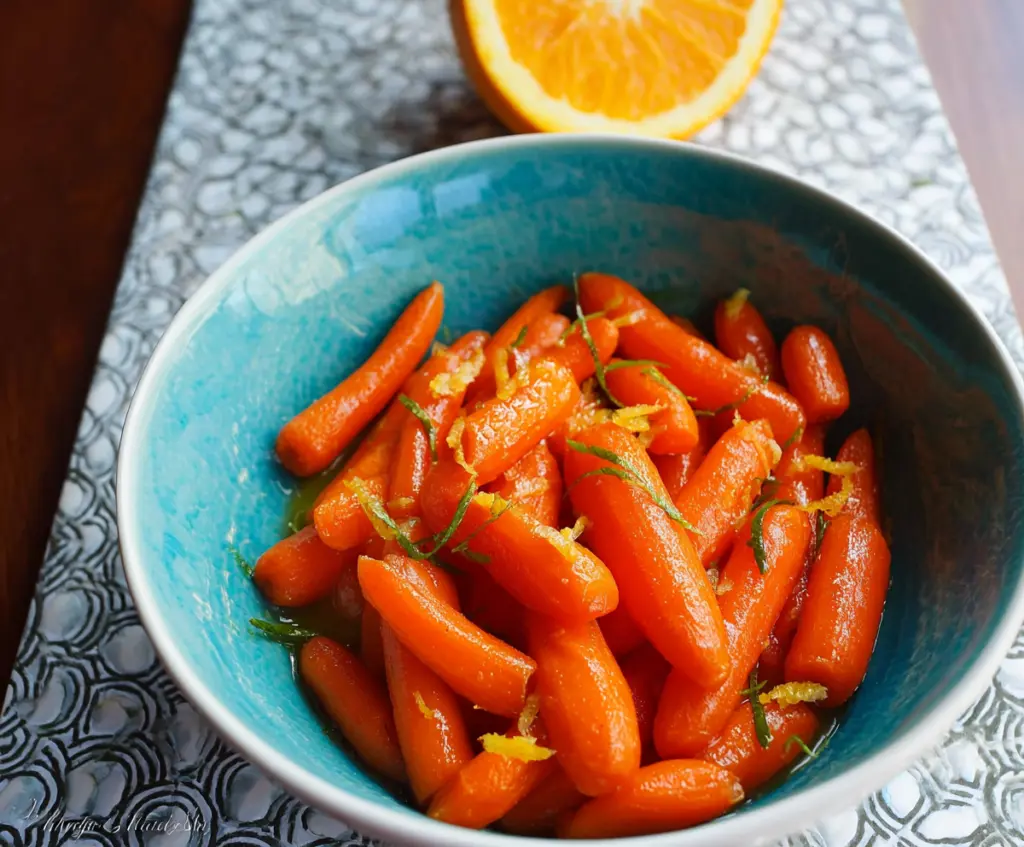 Savory glazed carrots with a hint of orange and ginger served on a plate.